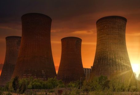 Atomic Aquatics - Exterior of huge cooling towers located in contemporary atomic power plant against bright setting sun under dramatic dark sky