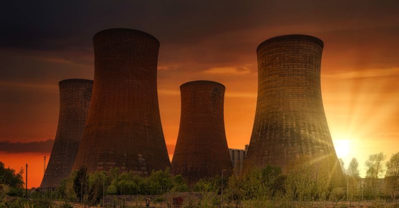 Atomic Aquatics - Exterior of huge cooling towers located in contemporary atomic power plant against bright setting sun under dramatic dark sky