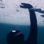 Wetsuit Cold - Anonymous diver in mask and wetsuit touching solid ice while swimming under seawater during freediving