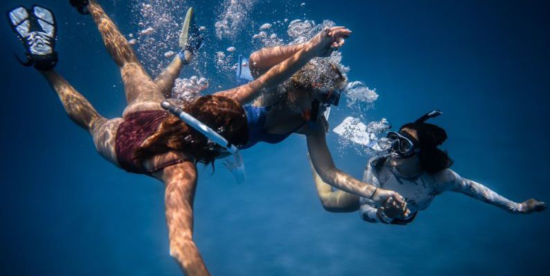 Underwater Communication - Group of young people with special equipment enjoying time together underwater with bubbles of oxygen