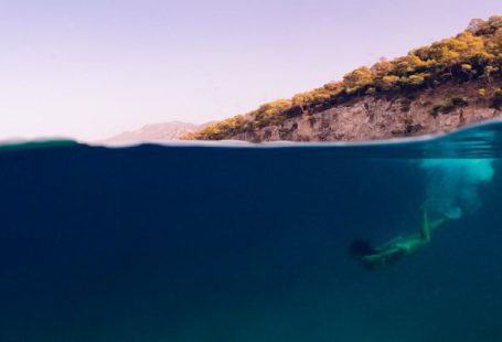Thailand Diving - A person swimming in the ocean with a ball floating above them