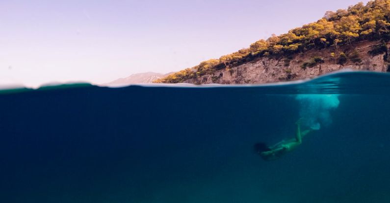 Thailand Diving - A person swimming in the ocean with a ball floating above them