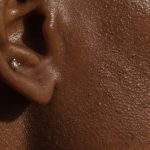 Ear Diving - Side view of crop face of anonymous African American lady with piercing in ear