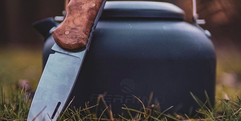 Renting Gear - A knife and a kettle sitting on the grass