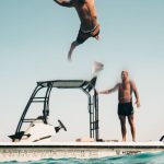 First Dive - Photo of Man Jumping from Boat to the Sea